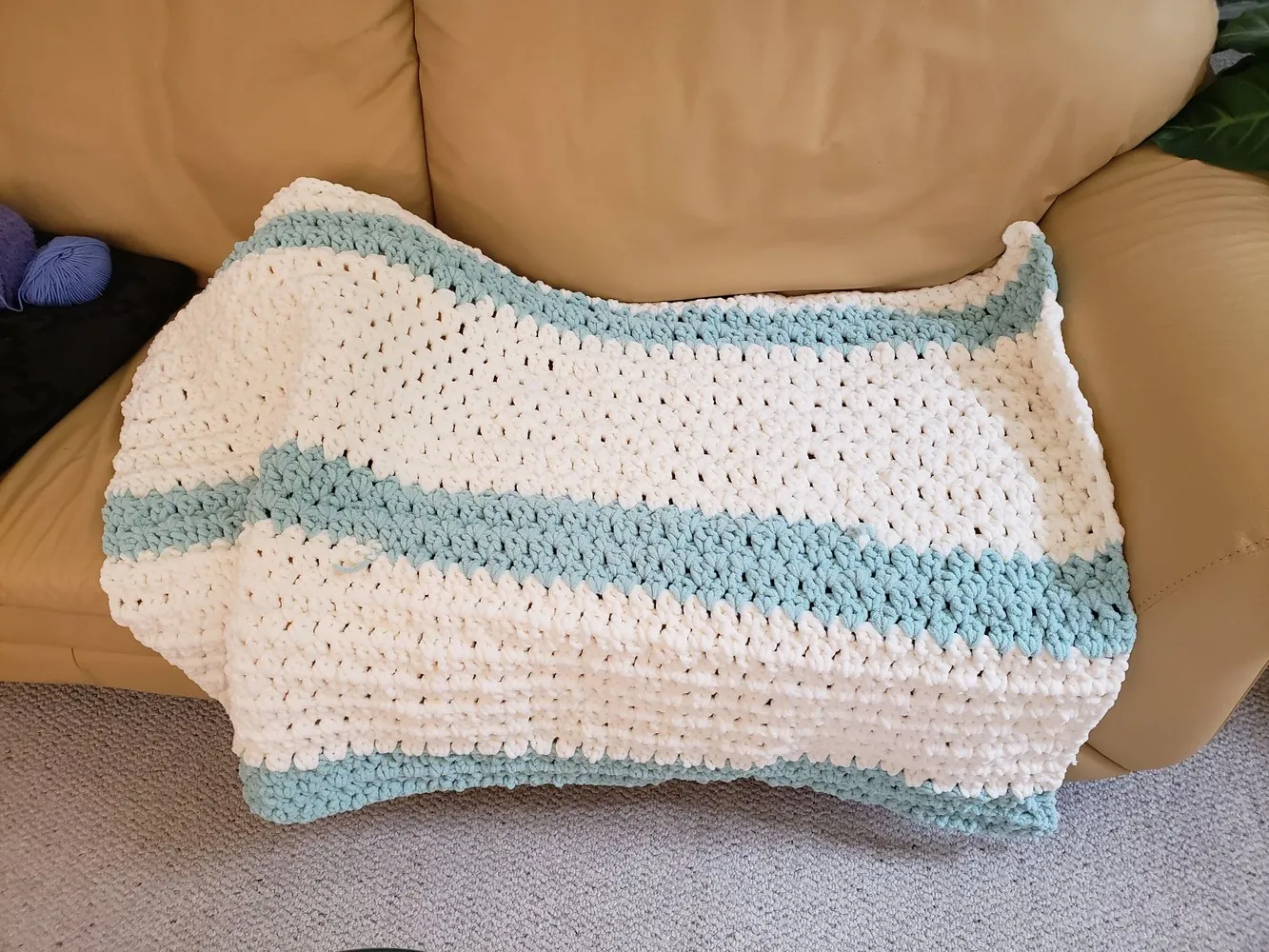 Crocheted blanket with blue and white stripes